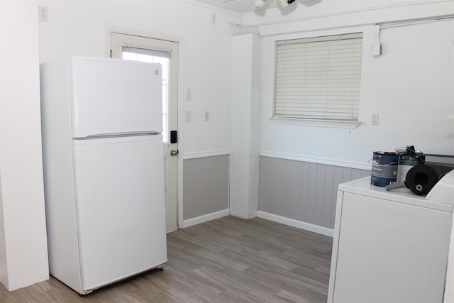 interior space featuring washer / clothes dryer, white refrigerator, and light hardwood / wood-style flooring