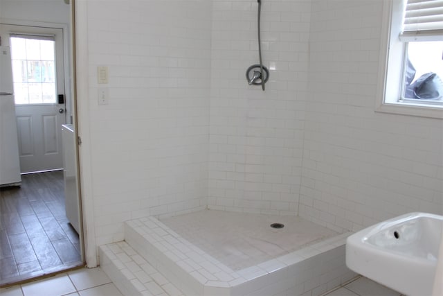 bathroom featuring wood-type flooring and tiled shower