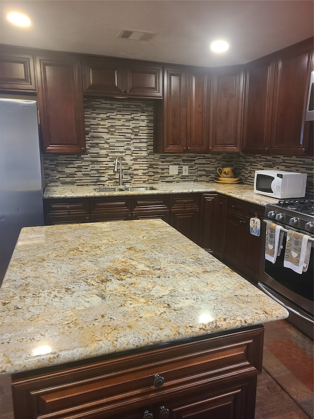 kitchen featuring stainless steel appliances, tasteful backsplash, and sink