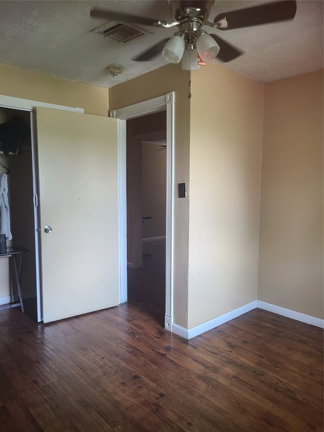 empty room with a textured ceiling, dark hardwood / wood-style floors, and ceiling fan