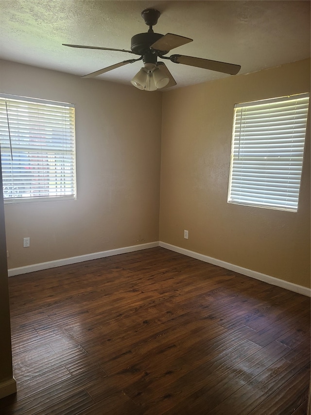 spare room with ceiling fan, a textured ceiling, and dark hardwood / wood-style flooring