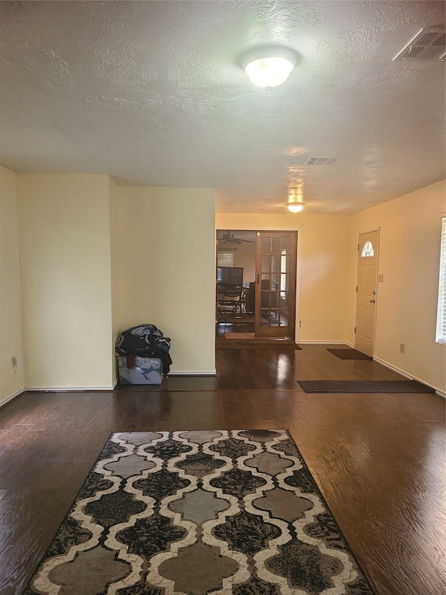 foyer featuring dark hardwood / wood-style floors and a textured ceiling