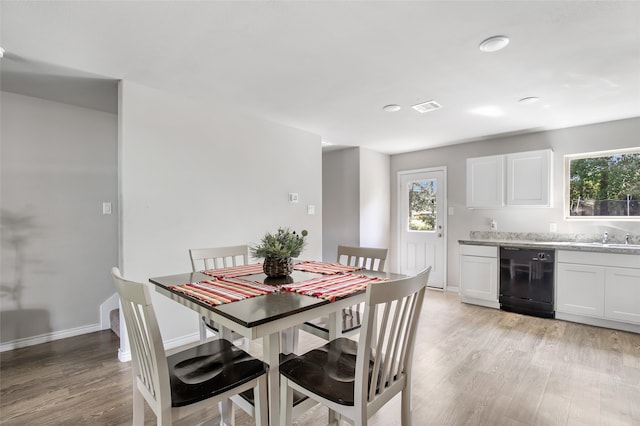 dining area with sink, light hardwood / wood-style flooring, and a healthy amount of sunlight