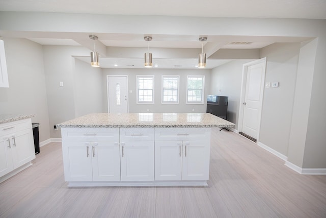 kitchen with decorative light fixtures, white cabinetry, light stone countertops, and light hardwood / wood-style floors