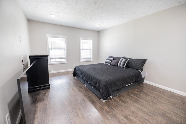 bedroom with dark hardwood / wood-style flooring and a textured ceiling