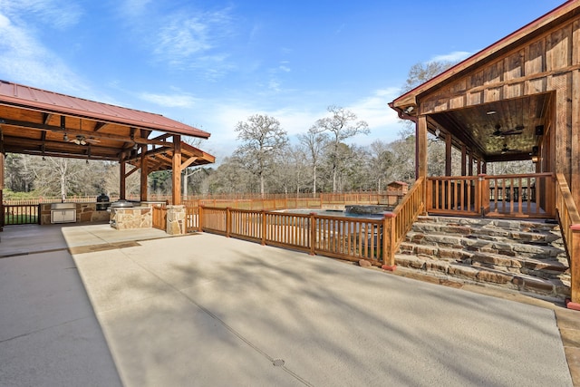 view of patio featuring a fenced in pool, ceiling fan, and exterior kitchen