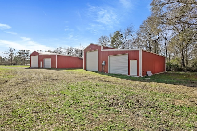 view of outdoor structure featuring a garage and a lawn