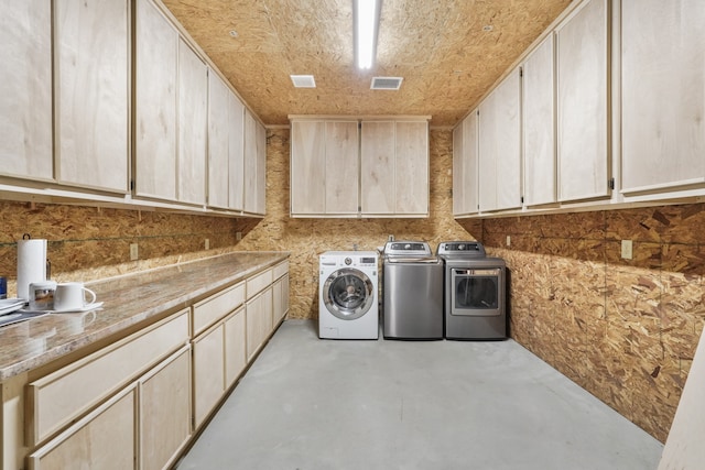 washroom featuring cabinets and independent washer and dryer