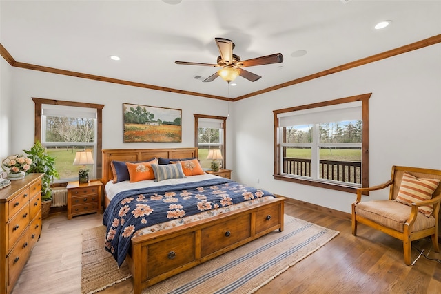 bedroom featuring ceiling fan, ornamental molding, and multiple windows