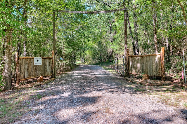 view of street featuring a gated entry and a view of trees