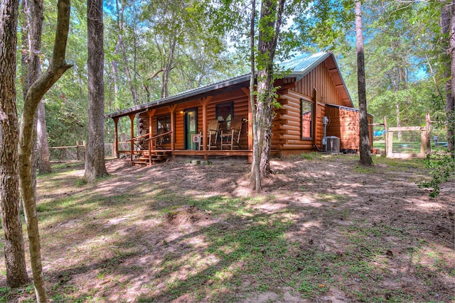 exterior space featuring central air condition unit, covered porch, metal roof, and log exterior