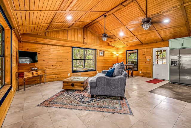 living room featuring wood walls, vaulted ceiling, light tile patterned floors, ceiling fan, and wooden ceiling