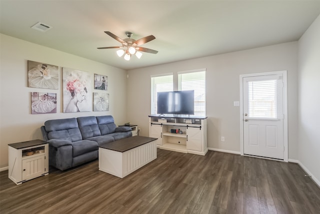 living room with dark hardwood / wood-style flooring, a wealth of natural light, and ceiling fan