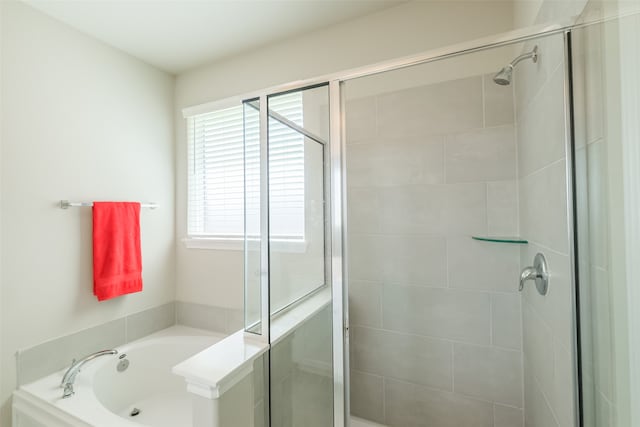 bathroom featuring plenty of natural light and separate shower and tub