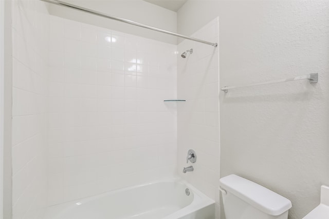 bathroom featuring toilet and tiled shower / bath