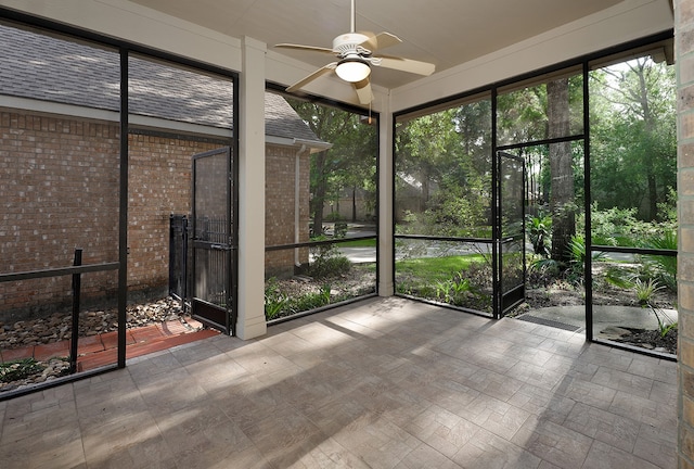 unfurnished sunroom with ceiling fan