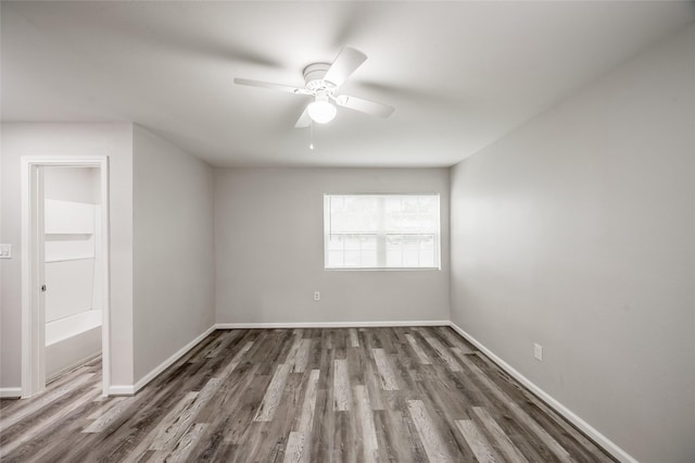 empty room featuring dark wood-type flooring, ceiling fan, and baseboards