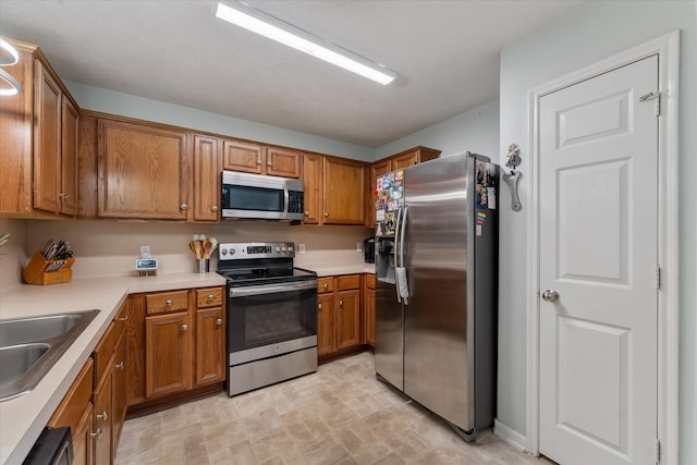 kitchen featuring sink, light tile patterned flooring, and stainless steel appliances