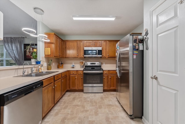 kitchen featuring sink, light tile patterned floors, pendant lighting, and stainless steel appliances