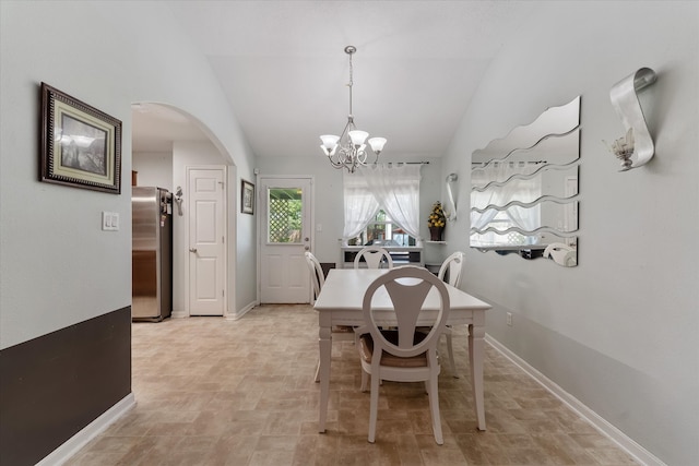 dining room with tile patterned flooring, vaulted ceiling, and a notable chandelier