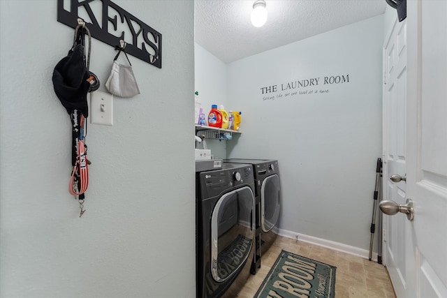 laundry room with light tile patterned floors, independent washer and dryer, and a textured ceiling