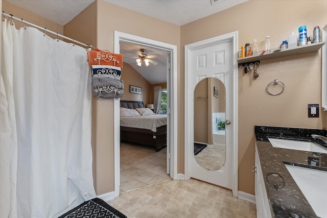 bathroom with ceiling fan, tile patterned flooring, a textured ceiling, and lofted ceiling