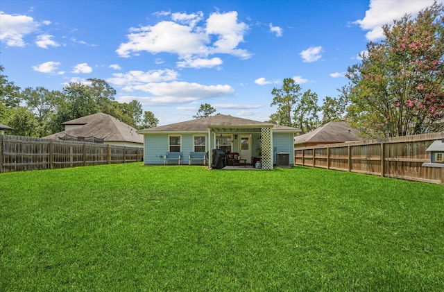 back of property with central air condition unit, a patio area, and a yard