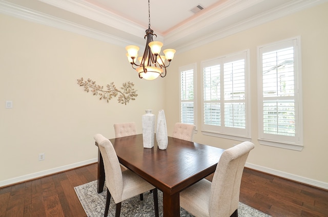 dining area with dark hardwood / wood-style flooring, a raised ceiling, a chandelier, and ornamental molding