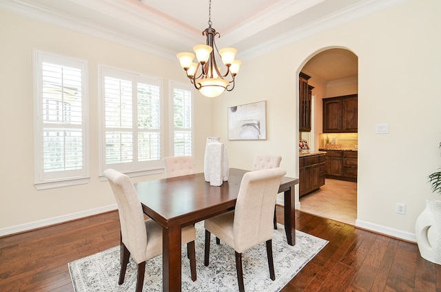 dining space featuring ornamental molding, a raised ceiling, an inviting chandelier, and tile patterned floors