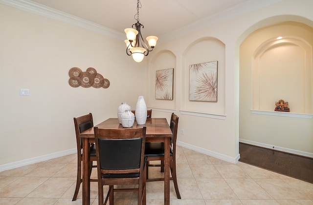 tiled dining space with an inviting chandelier and crown molding