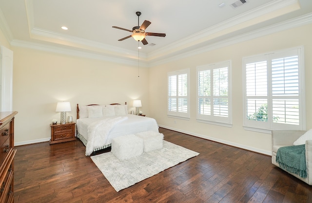 bedroom with dark hardwood / wood-style floors and a tray ceiling