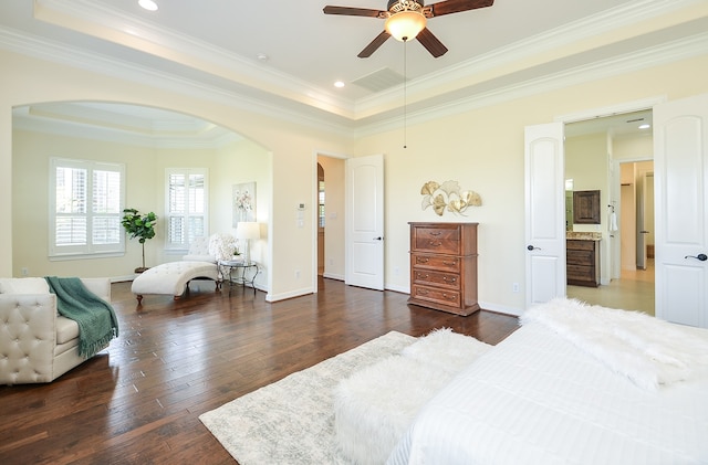 bedroom with crown molding, dark hardwood / wood-style flooring, and a tray ceiling