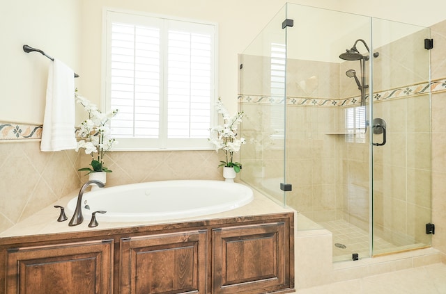 bathroom featuring tile patterned flooring, a healthy amount of sunlight, and separate shower and tub