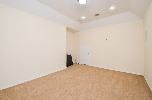 carpeted spare room with vaulted ceiling