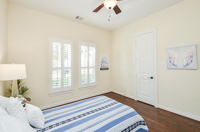 bedroom with multiple windows, dark wood-type flooring, and ceiling fan