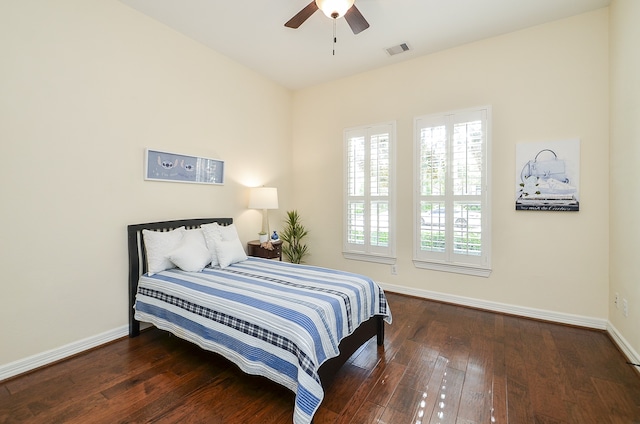 bedroom with hardwood / wood-style floors, ceiling fan, and multiple windows