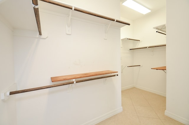 walk in closet with light tile patterned floors