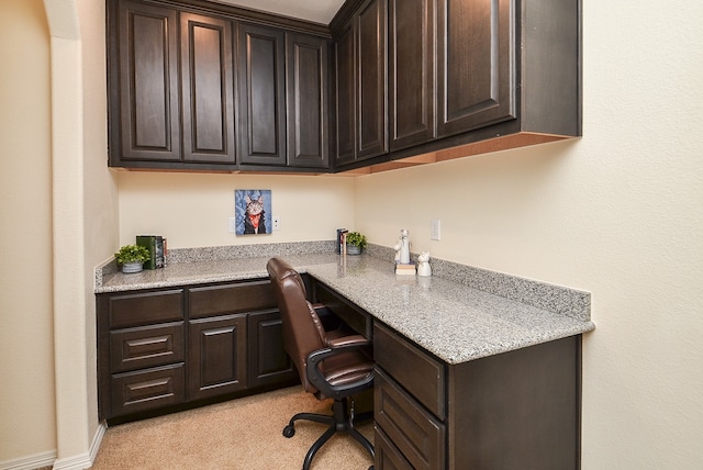 office space with built in desk and light colored carpet