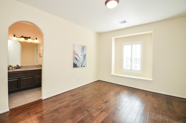 unfurnished bedroom featuring sink, connected bathroom, and tile patterned flooring