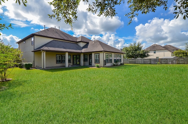 back of property featuring a yard