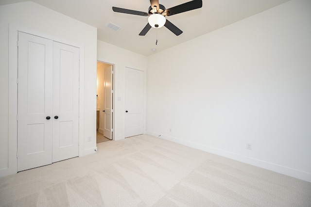 unfurnished bedroom featuring ceiling fan, light colored carpet, and a closet