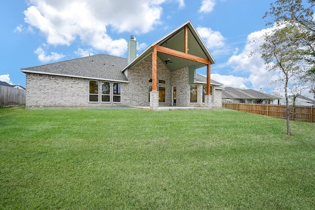 rear view of property with a yard and ceiling fan