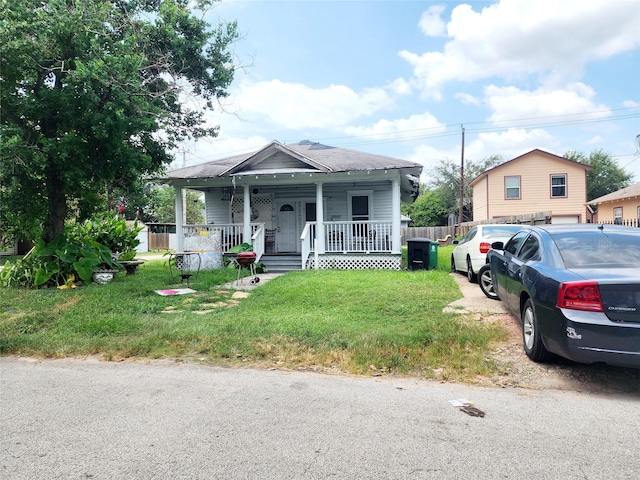 bungalow-style house featuring covered porch and a front lawn