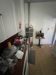 kitchen featuring white cabinetry and water heater