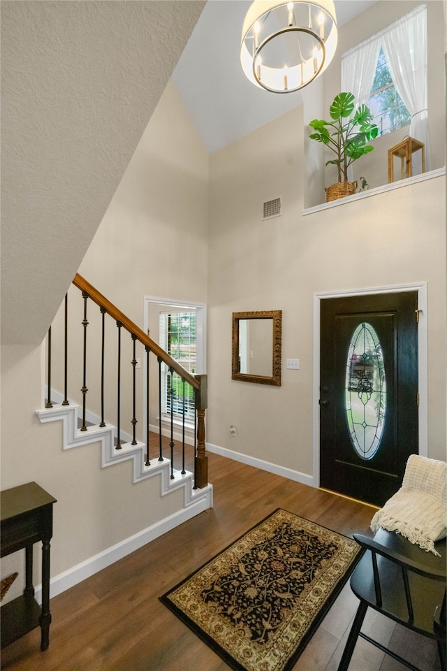 entrance foyer featuring high vaulted ceiling and wood-type flooring