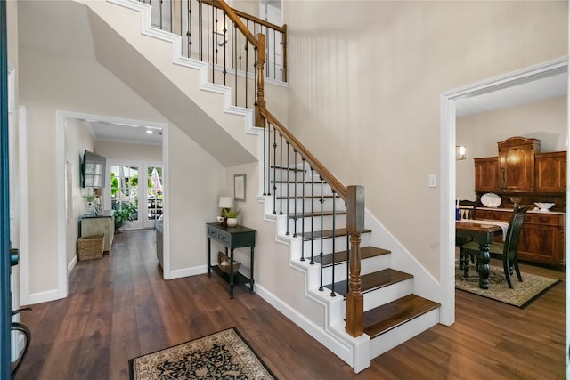 staircase with hardwood / wood-style floors, crown molding, and a high ceiling