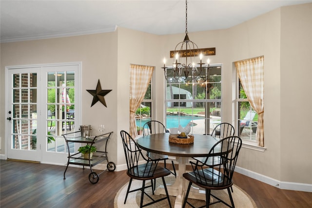 dining space with wood-type flooring, ornamental molding, and an inviting chandelier