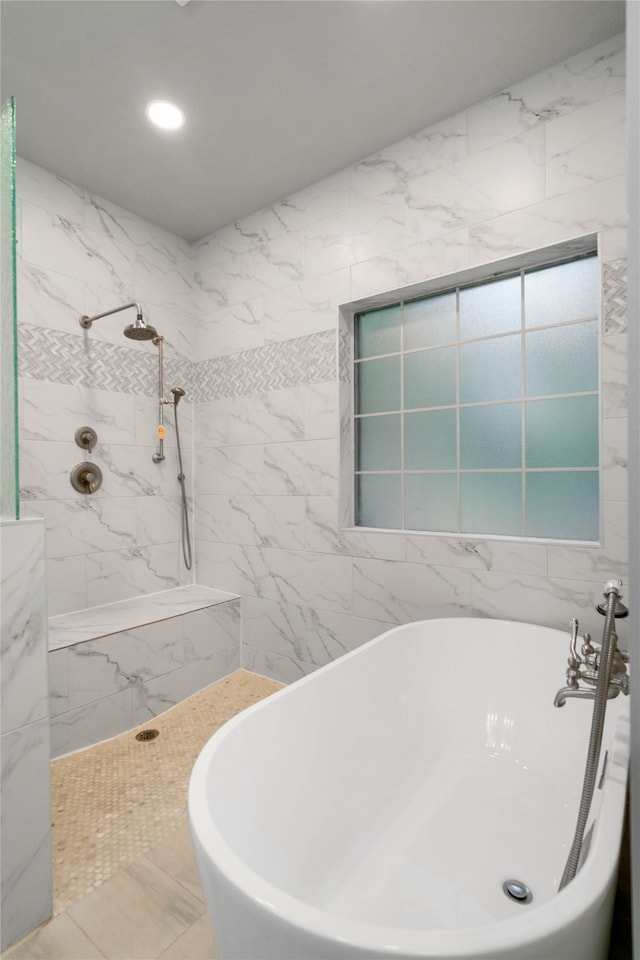 bathroom with a tub and tile walls