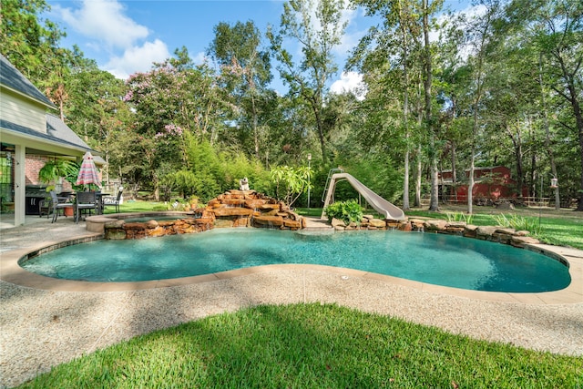 view of pool featuring an in ground hot tub, a patio area, and a water slide