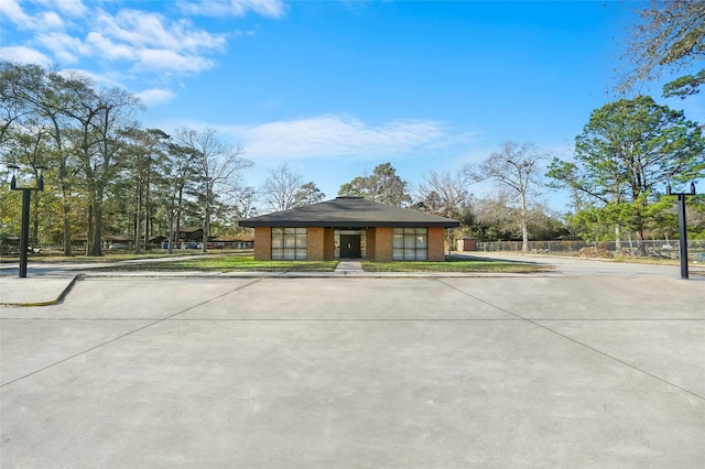 view of front of property with brick siding and fence